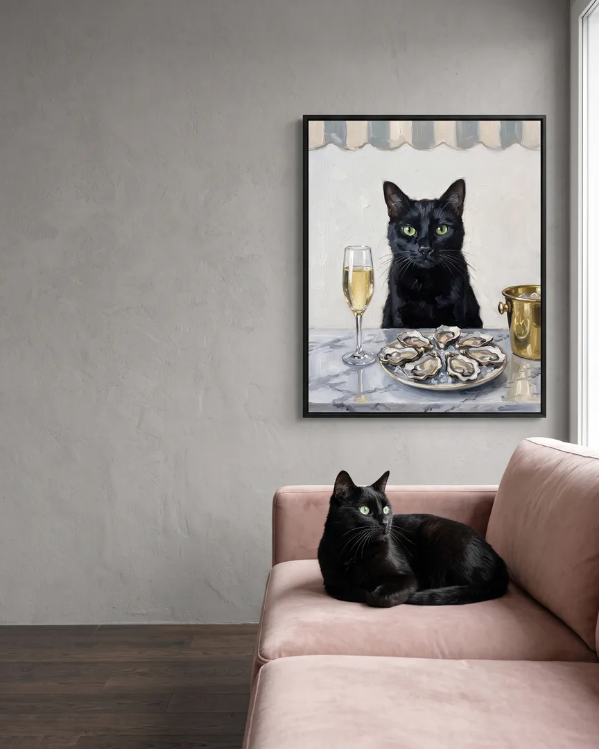 Ombre, un chat noir, à côté d'une toile encadrée noire de son portrait Perle et bulles.