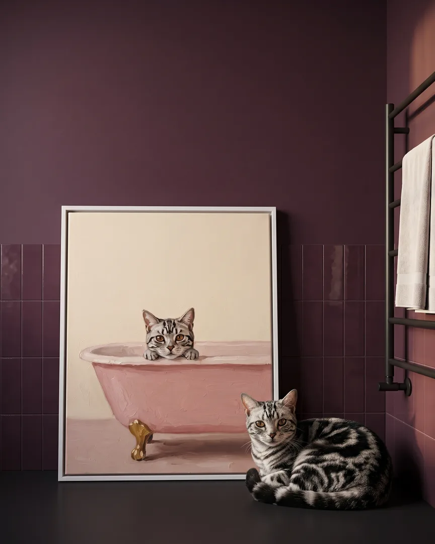 Smokey, a silver tabby domestic shorthair, beside a white framed canvas of their own Powder Pink Bath portrait.