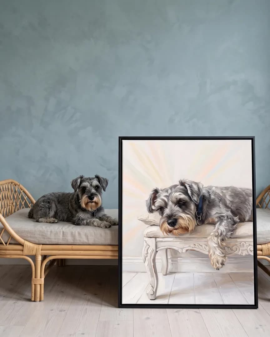 Otis, un schnauzer nain, à côté d'une toile encadrée noire de son portrait Lumière tranquille.
