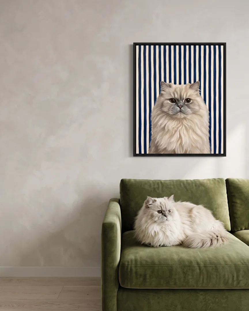 Frost, a Persian, beside a black framed canvas of their own Riviera Stripe portrait.