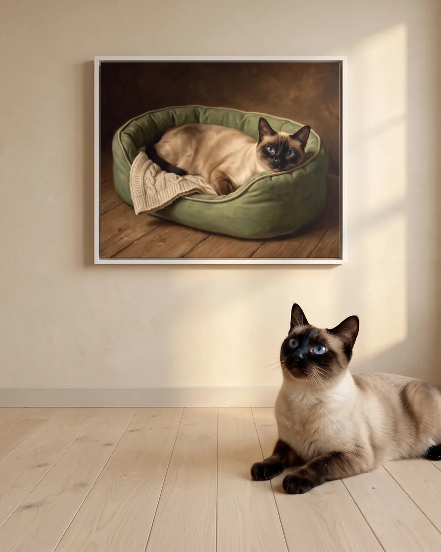 Sable, a Siamese, beside a white framed canvas of their own Snug Bed portrait.
