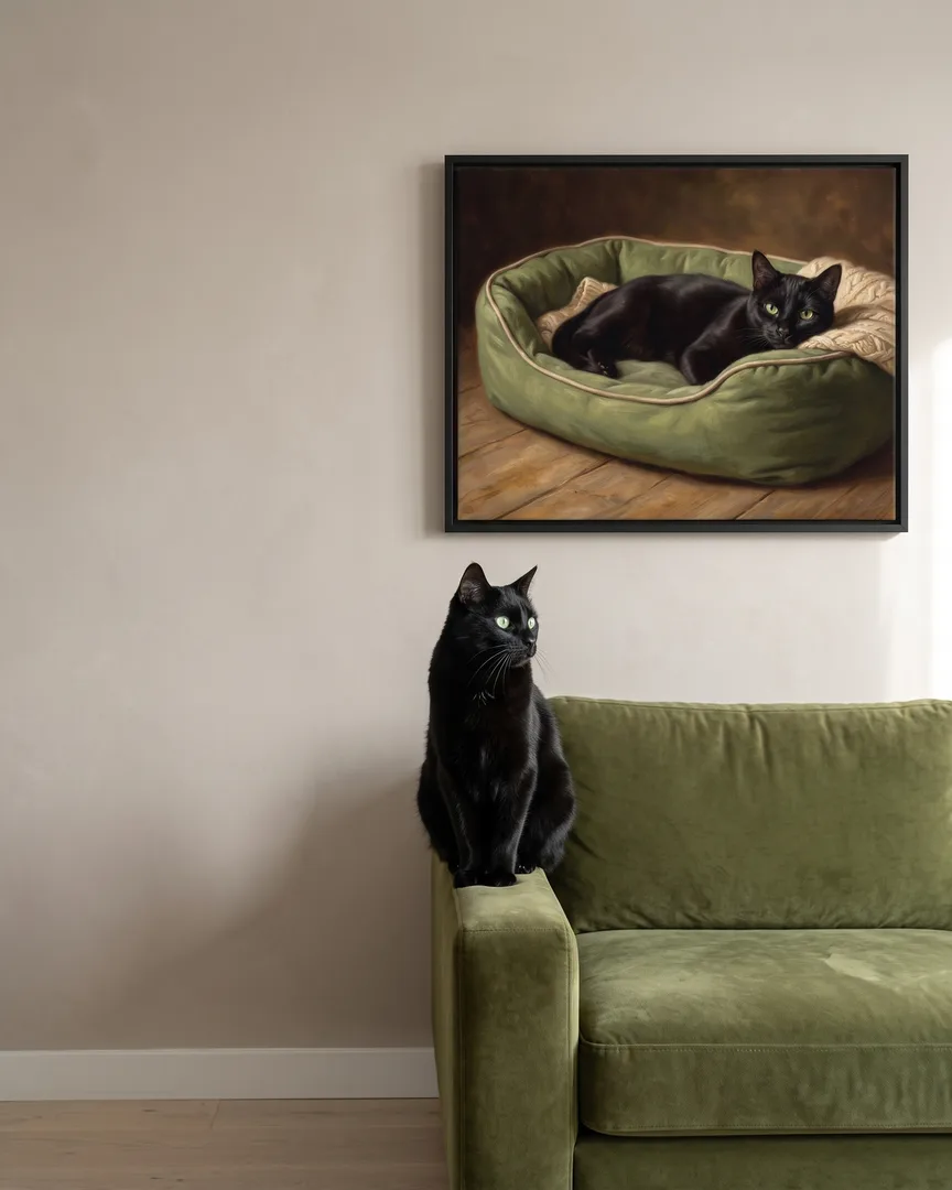 Ombre, a black domestic shorthair cat, beside a black framed canvas of their own Snug Bed portrait.