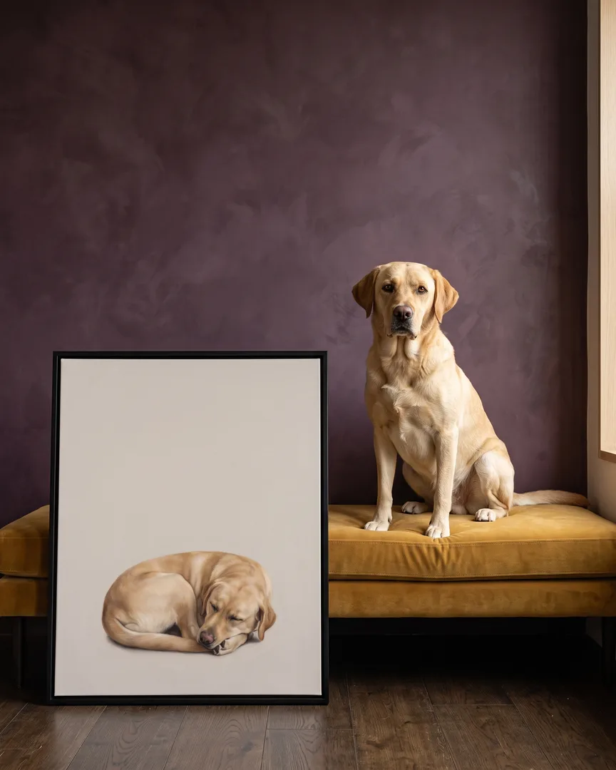 Marley, a yellow labrador retriever, beside a black framed canvas of their own Soft Hush portrait.