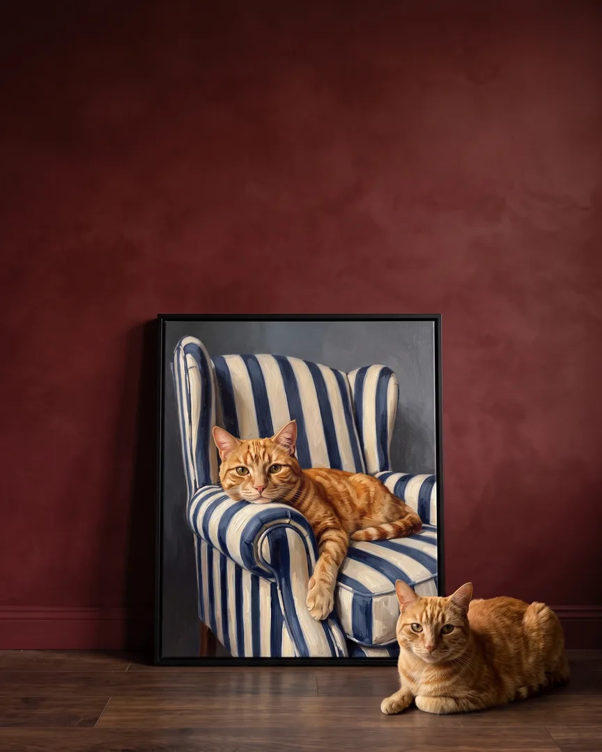Miel, un chat tigré, à côté d'une toile encadrée noire de son portrait Fauteuil.