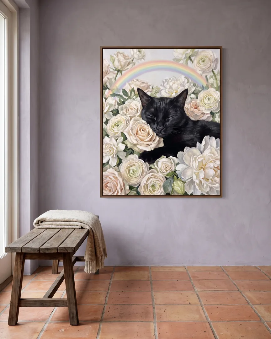 A brown framed canvas of Ombre, a black domestic shorthair cat, a White Roses portrait, hung above a garden bench.