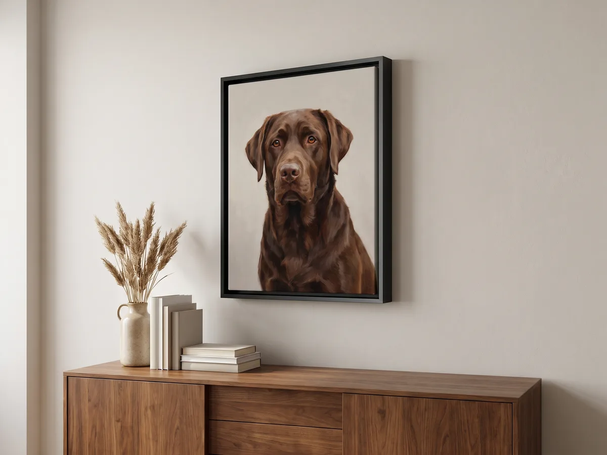 A portrait of a chocolate Labrador hanging in a living room as a canvas in a black float frame, with the gap between canvas and frame clearly visible